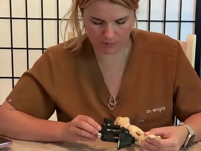 Dr. Kayla Wright demonstrating minimally invasive surgical instrumentation on a foot model.